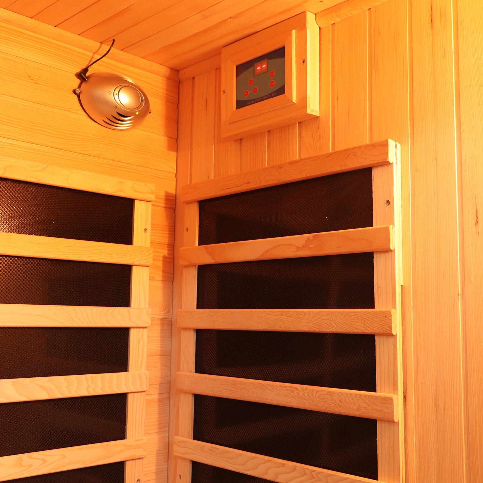 Valo 3 Person Carbon Fibre Infrared Indoor Sauna's interior features wood-paneled walls, black infrared heater panels with wooden slats, a digital control unit, and a silver speaker or vent for enhanced relaxation.