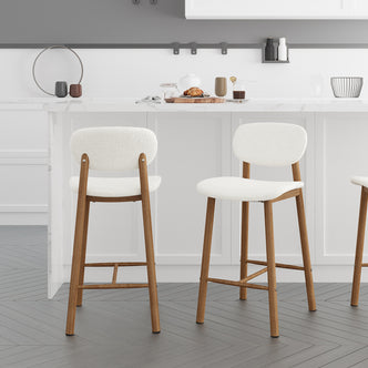 Afrim Boucle Upholstered High-Back Bar Stool Set of 2 features plush boucle upholstery, high backrest, and metal legs, shown near a counter with two chairs for a modern indoor setting.