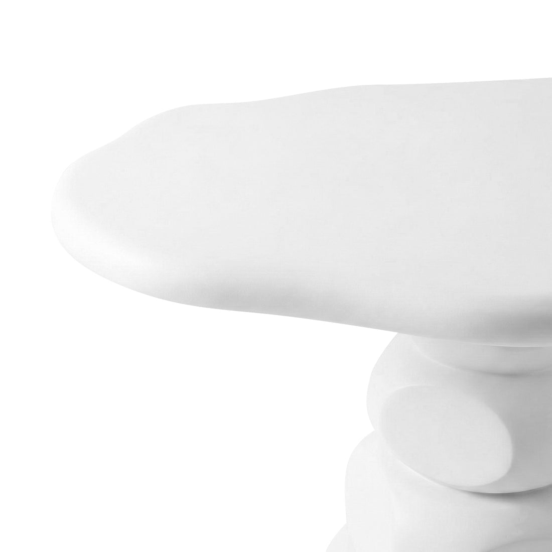 Close-up of curved white concrete table edge and sculptural pedestal base against white background