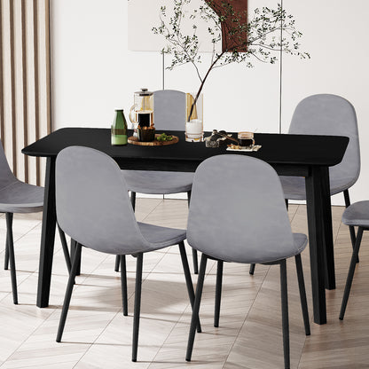 Connie 150cm 4 Seater Hardwood Dining Table in Black, featuring a matte-black rectangular tabletop with sturdy legs, surrounded by six light-gray upholstered chairs on a herringbone floor, showcasing a modern dining setup.