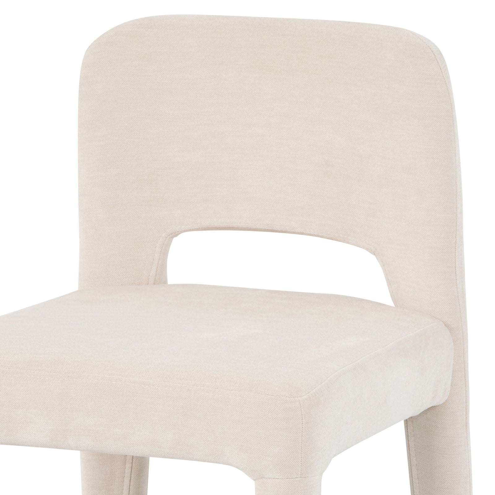 Close-up of Edris dining chair in oat upholstery showing curved backrest with cut-out detail and padded seat