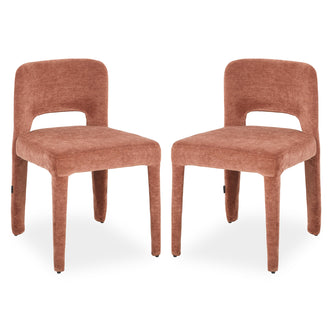 Two terracotta upholstered dining chairs with curved backs, cut-out detail and tapered legs