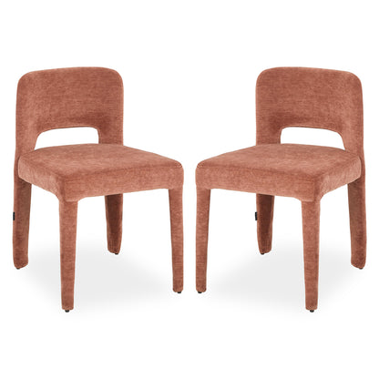 Two terracotta upholstered dining chairs with curved backs, cut-out detail and tapered legs