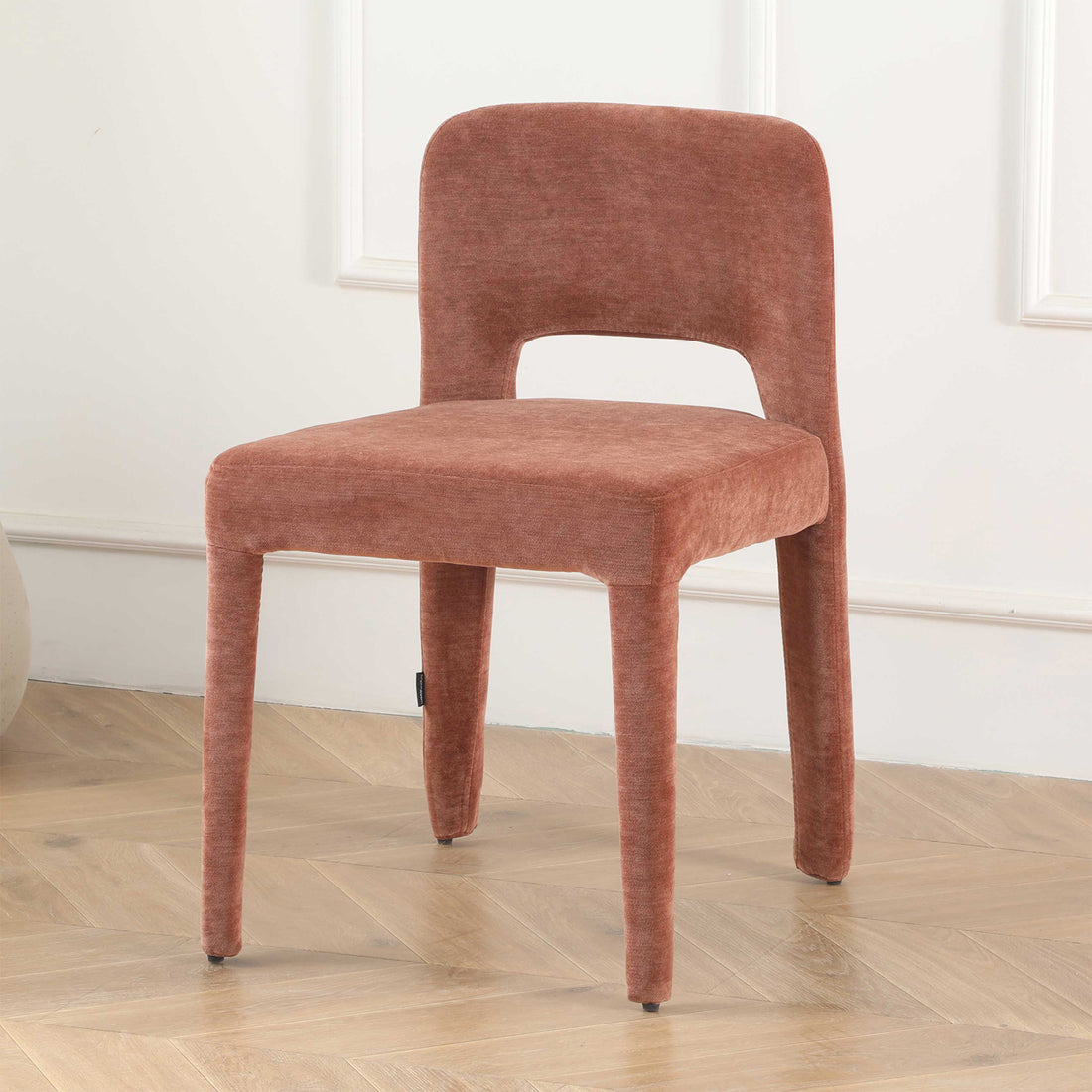 Edris upholstered dining chair in terracotta with curved backrest, cut-out detail and tapered legs