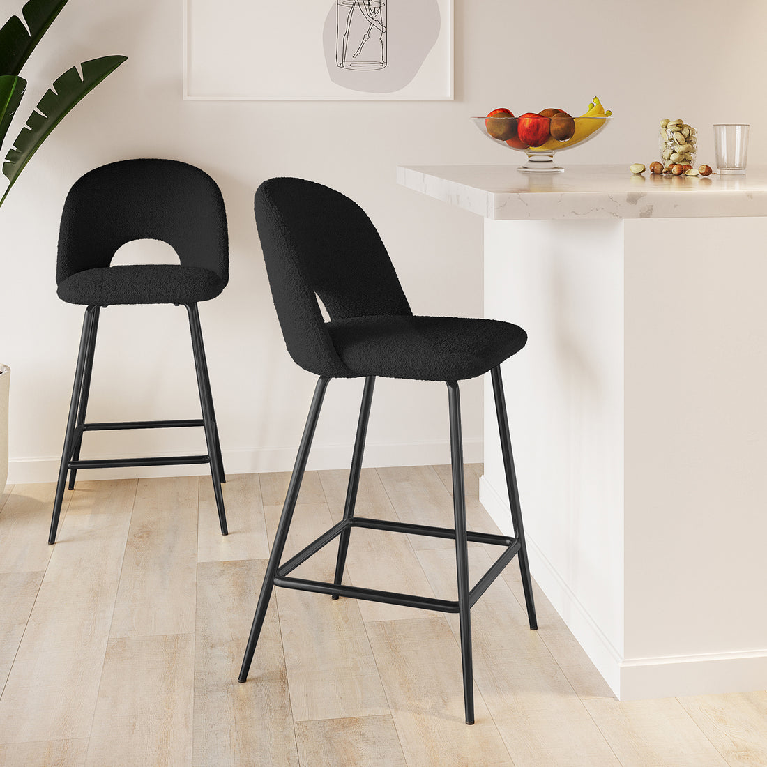 Evie High Back Boucle Bar Stool Set of 2 in Black beside a marble-look counter, showcasing their sleek metal legs and plush upholstery in a modern kitchen setting.