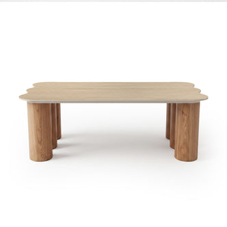 Light wood table with scalloped edges and cylindrical legs on white background