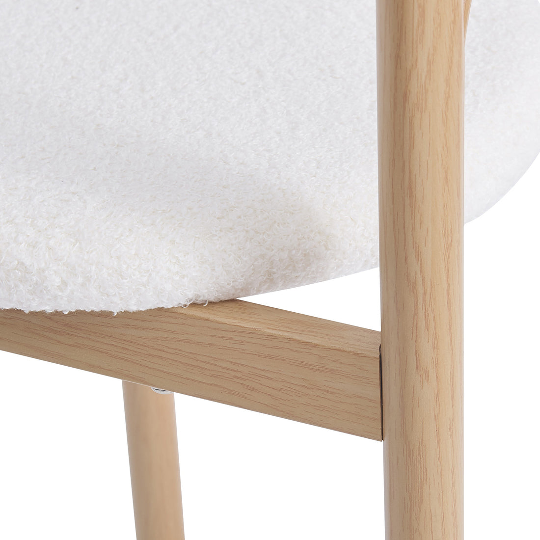 Close-up of Gilles Boucle Arched Dining Chair Cream White Set of 2, showcasing the textured wood grain on the powder-coated metal frame and boucle fabric, highlighting the elegant double-arched backrest design.