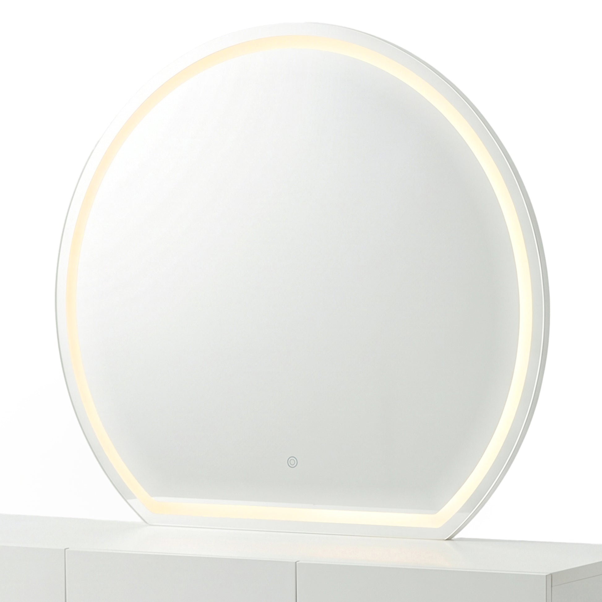 Modern round makeup mirror showing the warm yellow light setting on a white console table.