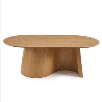 Contemporary wooden table with an oval top and sculptural base on white background