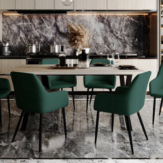 Raynie Velvet Dining Chair Set of 2 in Deep Green, featuring plush velvet upholstery, foam padding, and sleek black metal legs, elegantly surrounds a light wood dining table in a modern kitchen setting.