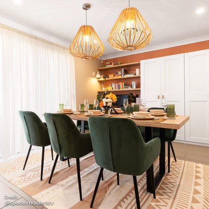 Raynie Velvet Dining Chair Set of 2 in Deep Green, featuring plush velvet upholstery, slim black legs, and positioned around a light-wood table in a warmly-styled dining room, enhancing modern elegance.
