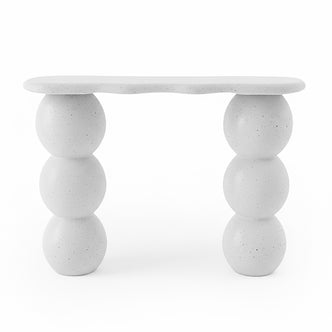 Modern white console table with wavy edges and stacked sphere legs on a white background