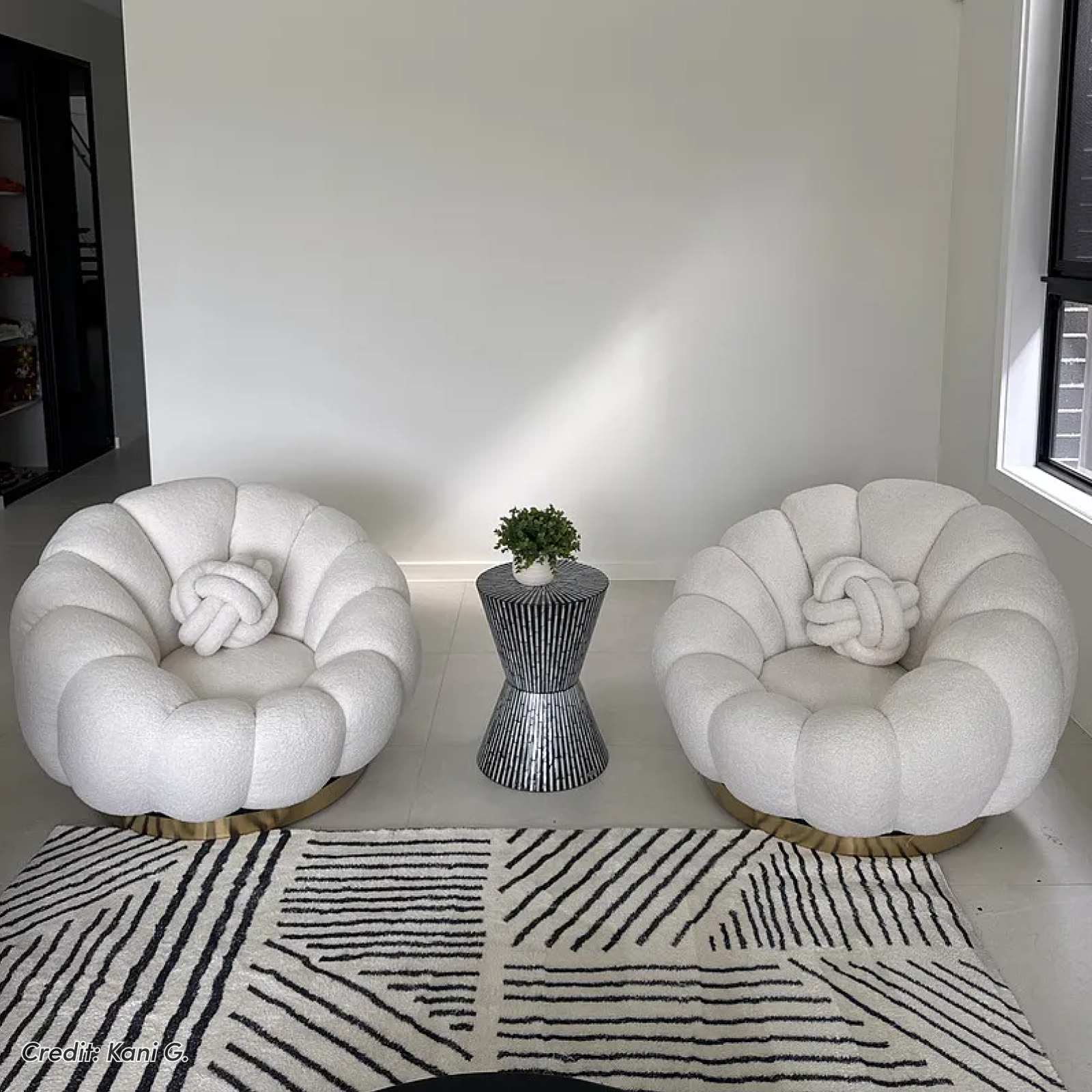 Pair of white bouclé accent chairs with knot cushions and side table