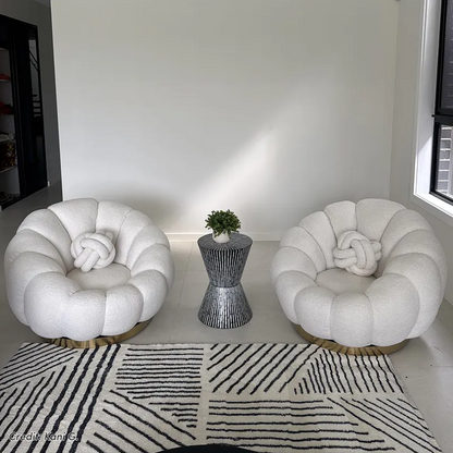 Pair of white bouclé accent chairs with knot cushions and side table