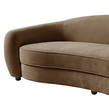 Close-up of curved armrest and seat cushion of warm taupe brown velvet sofa with black legs on white background