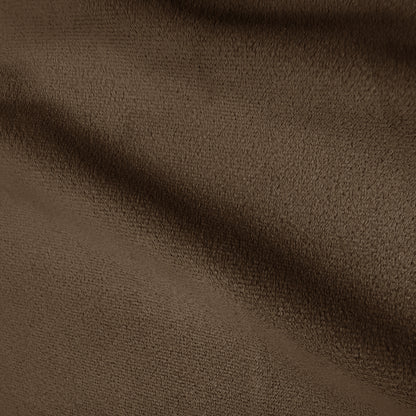 Close-up of warm taupe brown velvet upholstery texture showing soft pile and gentle shadowing