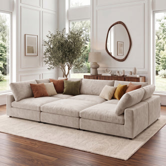 Beige sectional sofa styled in a bright modern living room with pillows and decor.