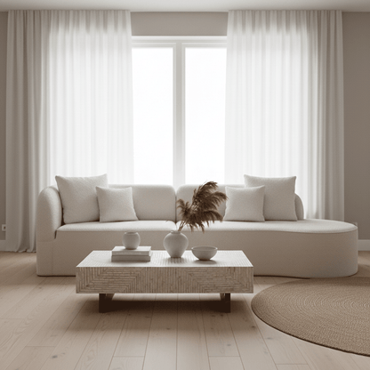 Hattie 4 Seater Boucle Sofa in Cream White, showcasing its curving design, plush texture, and matching throw pillows, sits invitingly in a bright, minimal-modern living room with ocean views.