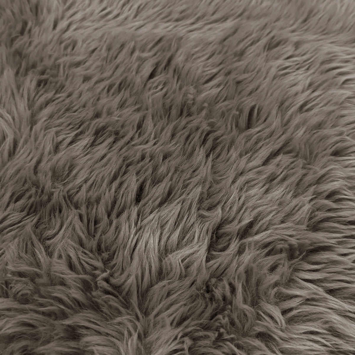 A macro close-up texture view of the taupe faux-fur or sheepskin material, showing the dense, long-pile fibers.