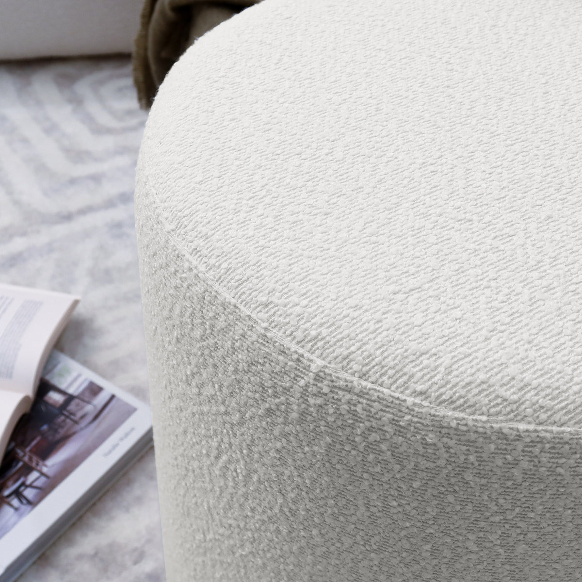 Close-up of the Hiboa Bouclé Ottoman Stool, showcasing its plush texture and curved design, ideal for stylish, multi-use seating.