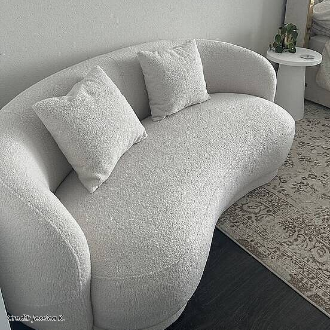Curved white boucle sofa with matching cushions in living room