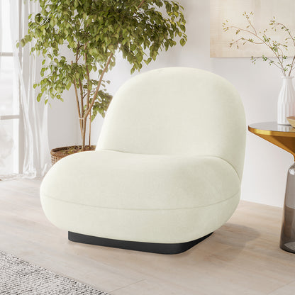 Cream velvet swivel accent chair with curved silhouette and black base