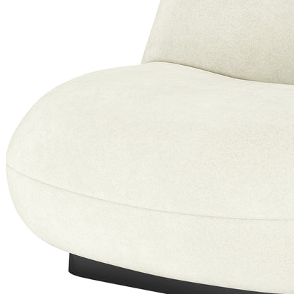 Close-up of cream velvet swivel accent chair seat with curved edges and black base