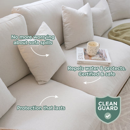 Millie Fabric Ottoman Modular Sofa in light beige, featuring three throw pillows, an open book titled STILL, and a cream mug; highlighted benefits include spill protection and durability with a CLEAN GUARD certification.