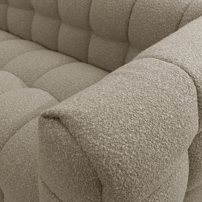 Close-up of the Norah 5-Seater Boucle Sofa Set with Armless Chairs in warm beige, showcasing the textured, tufted upholstery meeting the armrest, highlighting its luxurious boucle fabric and plush comfort.