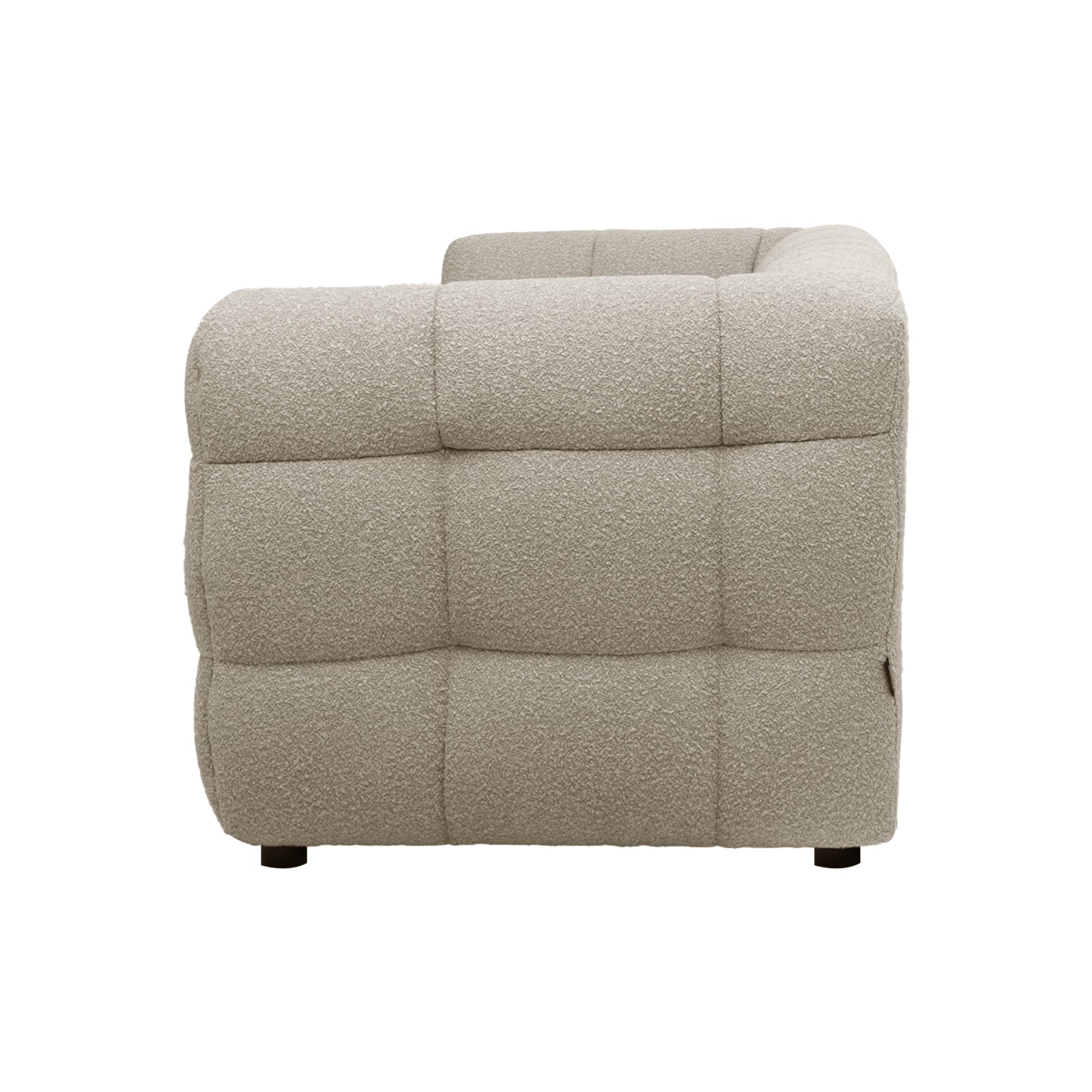 Side view of the Norah sofa in warm beige boucle, showing tufted quilted upholstery and rounded armrest