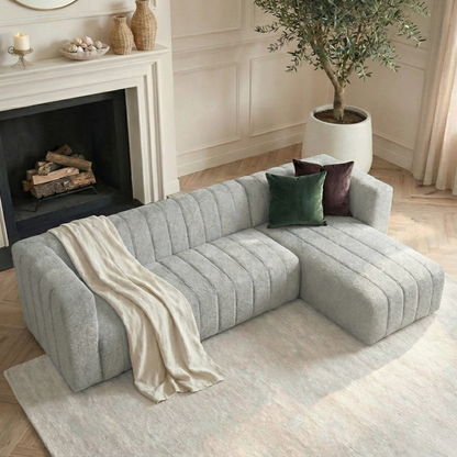 Grey boucle chaise sofa with green cushions in elegant living room