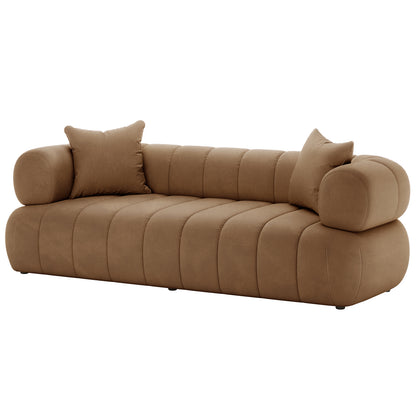 Samira 3 Seater Velvet Sofa - Camel Brown features a plush velvet upholstery with two matching pillows, showcasing a luxurious design. The close-up highlights the sofa's elegant texture and comfortable cushioning.