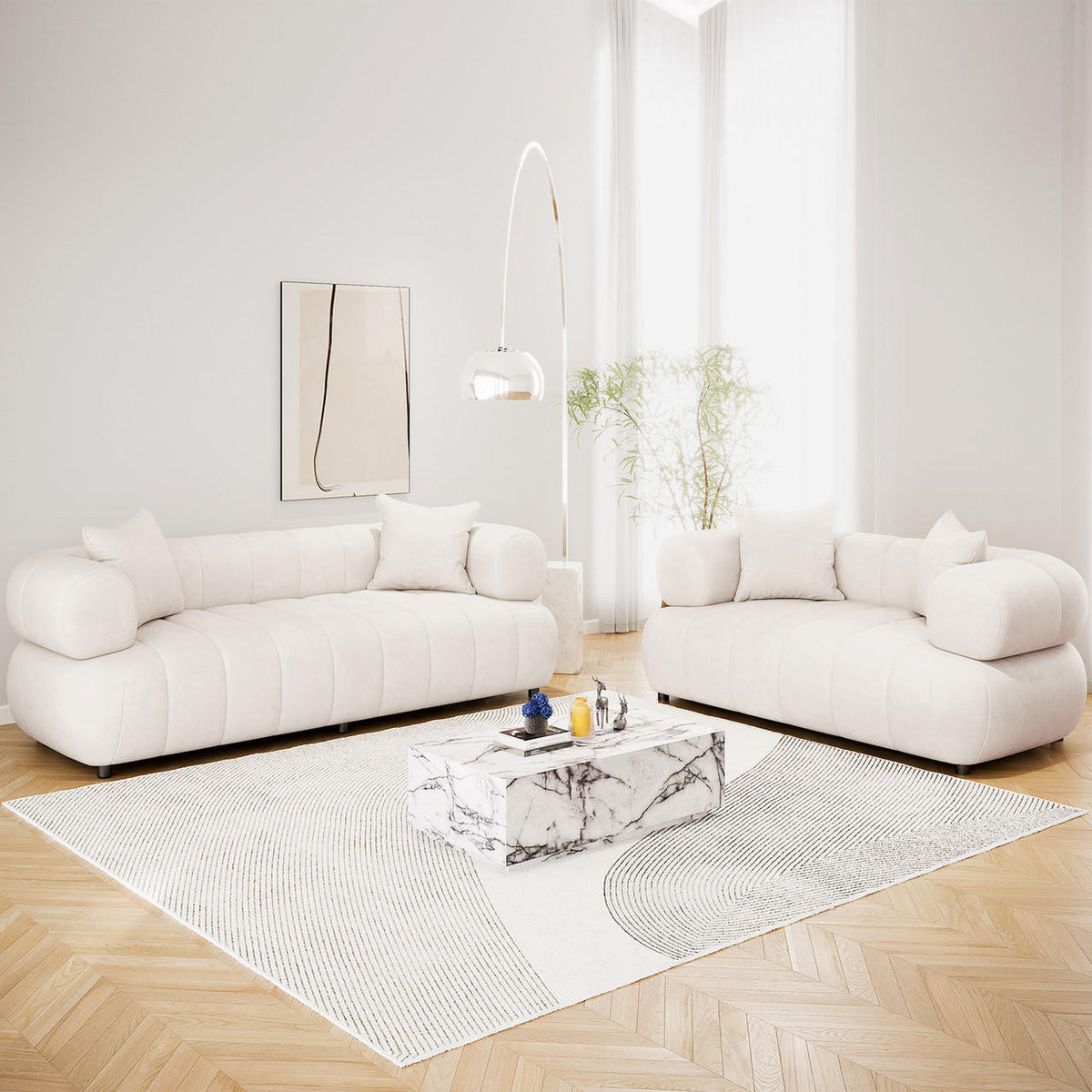 Samira 5 Seater Velvet Sofa Set in Cream, featuring low-profile sofas with cylindrical bolster arms, matching throw pillows, and plush cream velvet upholstery, elegantly arranged in a bright, minimalist living room.