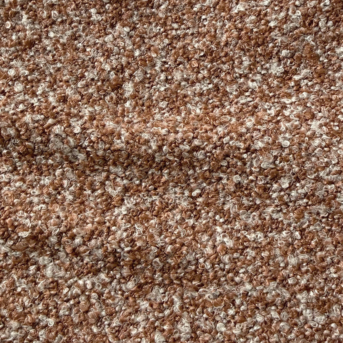 Close-up of the Sornel Boucle Upholstered Accent Chair in Coral, showcasing its textured boucle fabric with looped, curly fibers, highlighting the chair's tactile and high-density comfort design.