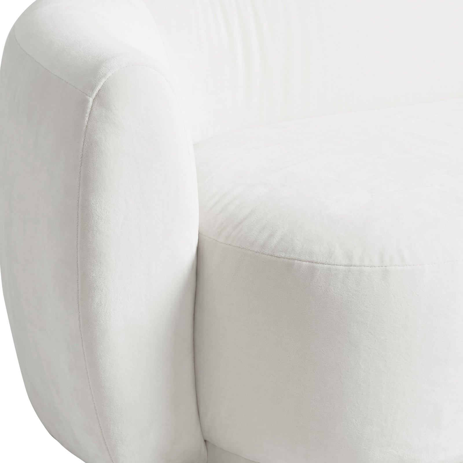 Close-up of curved cream velvet sofa arm and cushion detail