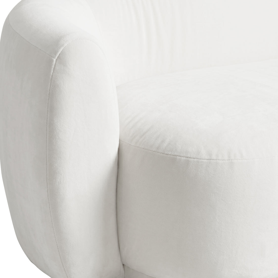Close-up of curved cream white velvet sofa showing armrest and cushion seam detail