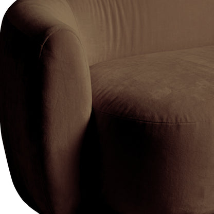 Curved taupe brown velvet sofa with plush rounded armrest and visible seam detail