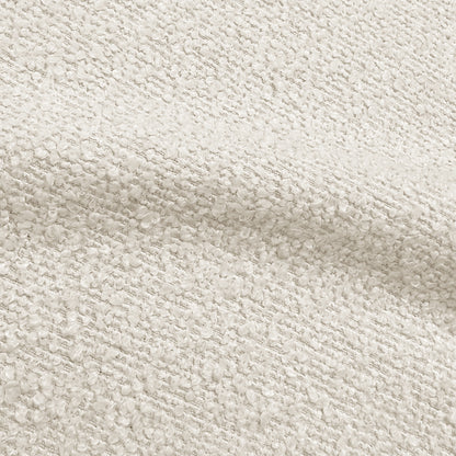Close-up of cream white boucle fabric texture showing woven looped fibres