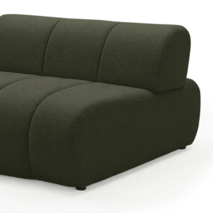 Close-up of curved modular sofa arm and backrest in dark forest green boucle fabric on white background