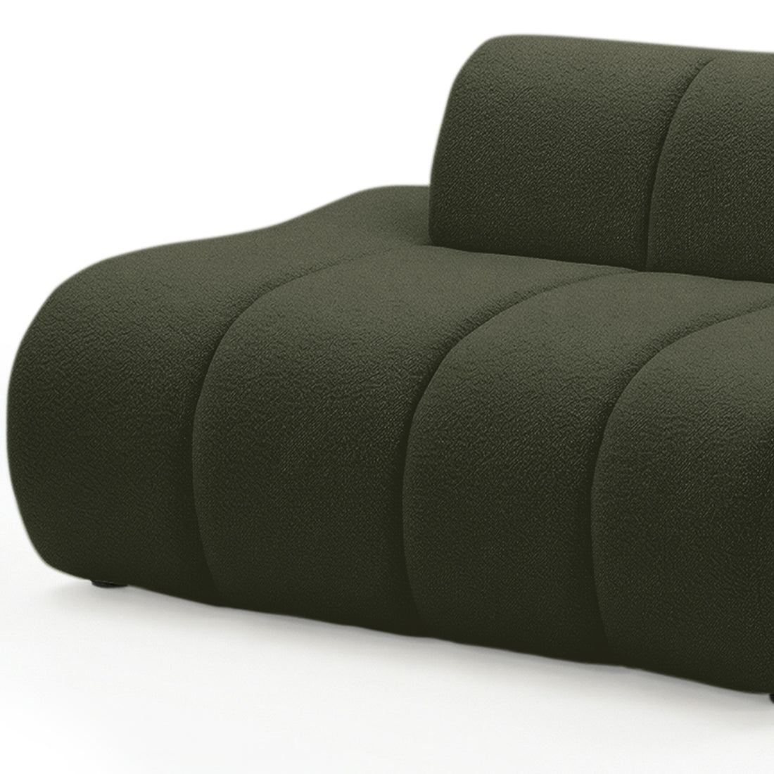 Close-up of curved modular sofa in dark forest green boucle fabric showing rounded arm and channel detailing on white
