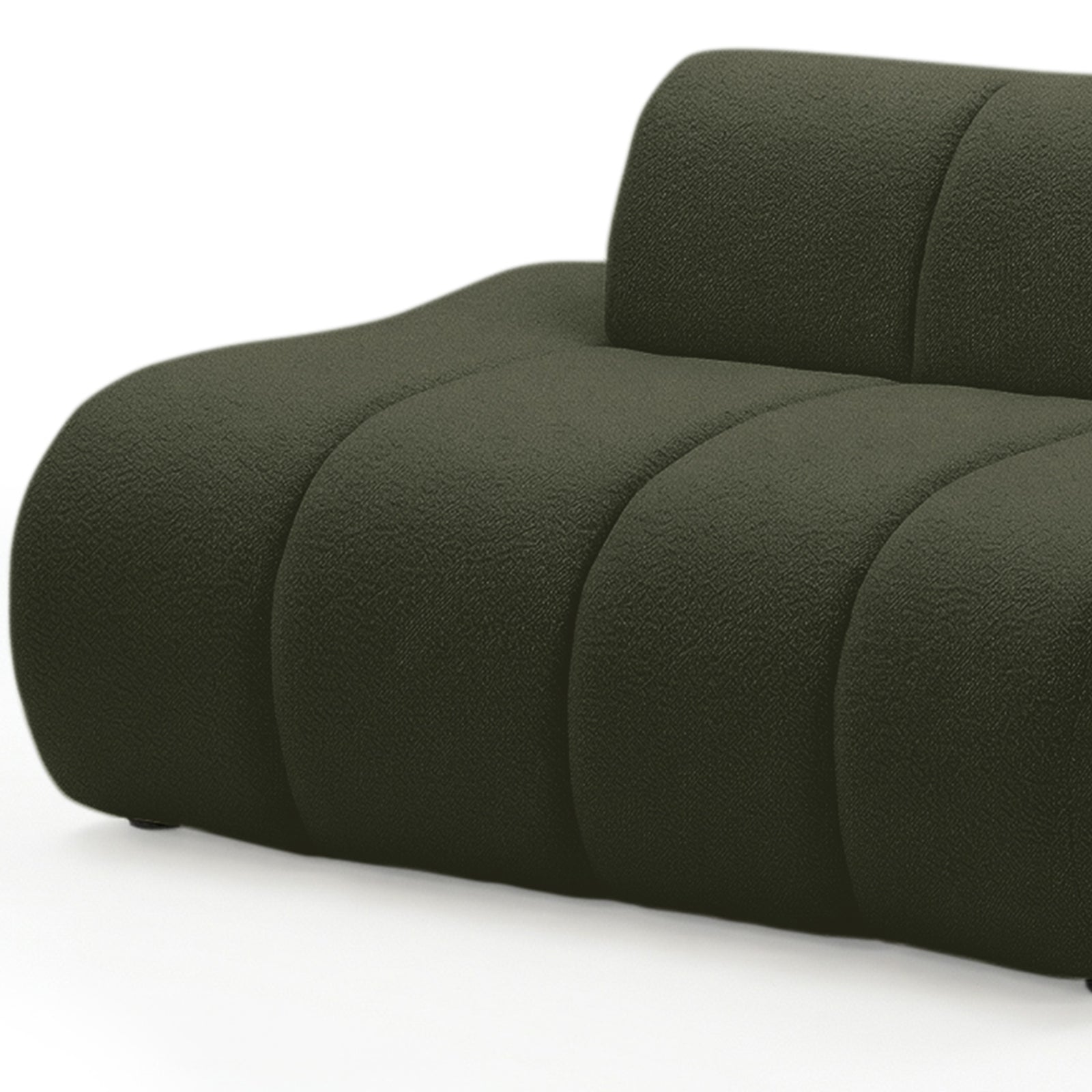 Close-up of curved modular sofa in dark forest green boucle fabric showing rounded arm and channel detailing on white