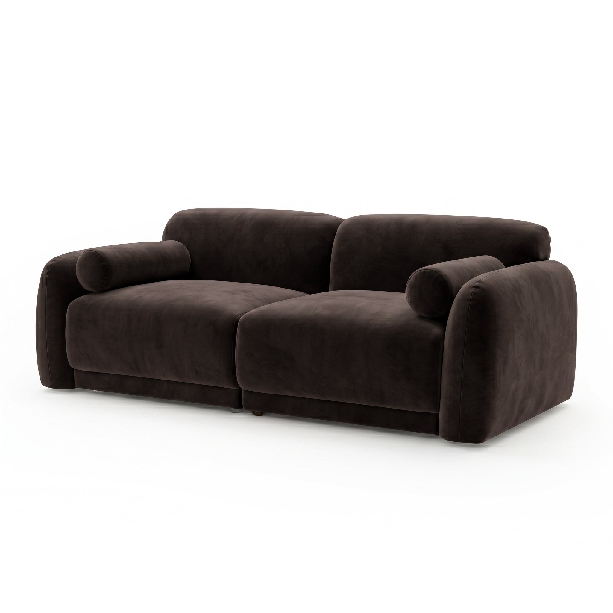 Dark brown velvet sofa with rounded armrests and cylindrical bolster pillows on white background