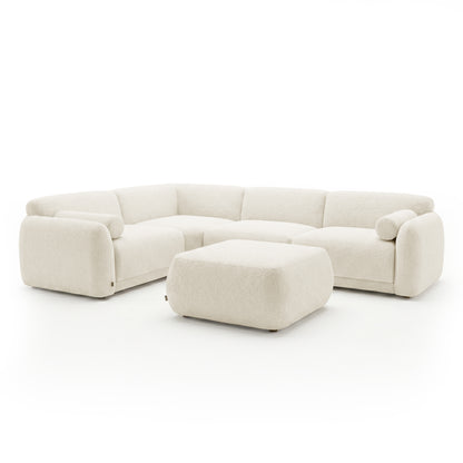 Cream sectional sofa with matching ottoman on a white background