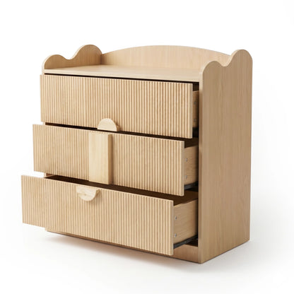 A three-drawer chest of drawer featuring a textured, fluted wood finish, a scalloped top edge, and unique semi-circular handles.