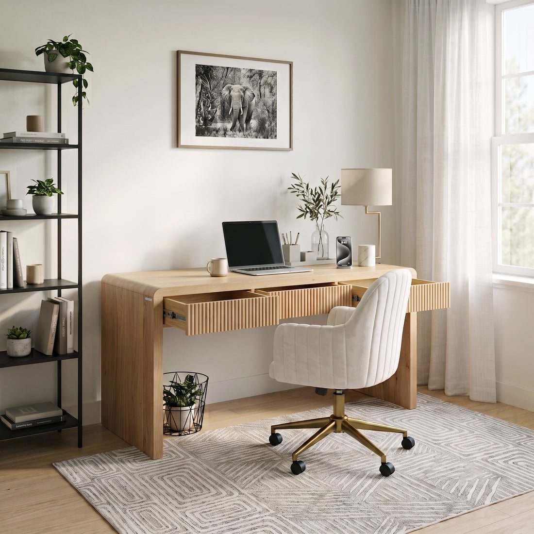 Modern light wood desk styled in a bright home office with chair, lamp, plants, and decor.