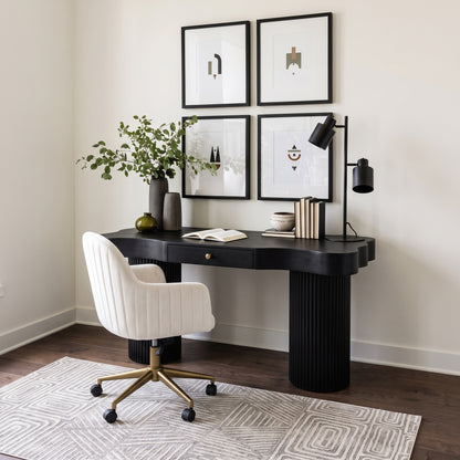 Black desk styled in a modern home office with chair, decor, and wall art