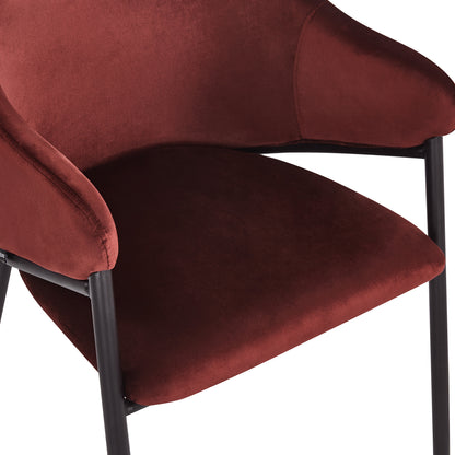 Close-up detail of burgundy velvet chair’s seat and armrest on white background