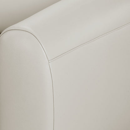 Close-up of a light-colored upholstered sofa armrest with stitching