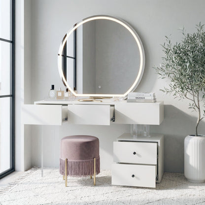 White vanity table and round LED mirror in a softly lit room with pink stool and potted plant