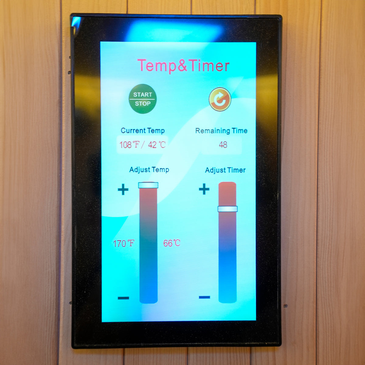 Digital sauna control panel mounted on a wooden wall